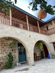 an external view of a stone house with a balcony at Florence Dreaming House in Pissouri