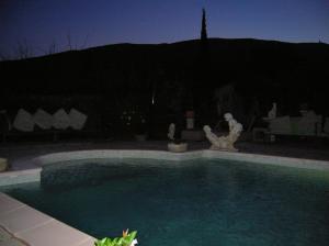 a swimming pool in a yard at night at Le Mas des Baux in Bédoin