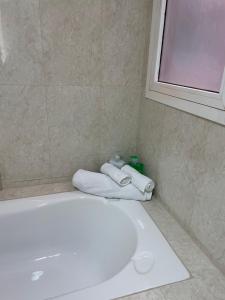 a bathroom with a tub and two folded towels at J V Dubai in Dubai