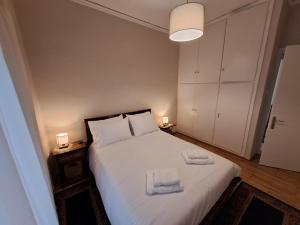 sypialnia z białym łóżkiem i 2 ręcznikami w obiekcie Patras Stay w mieście Patras