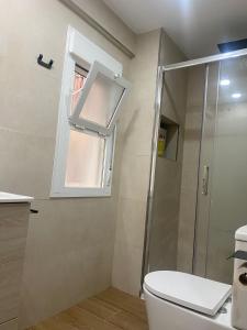 a bathroom with a toilet and a glass shower at Castel Málaga Home in Málaga