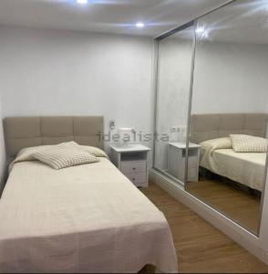 a bedroom with two beds and a mirror at Castel Málaga Home in Málaga