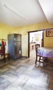 a kitchen with a refrigerator and a table in a room at Ecos del Alma - Casas de Campo in Tupungato