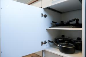 une cuisine avec des casseroles et des poêles sur une étagère dans l'établissement Spacious Apartments with View & Free Parking, à Wiener Neustadt
