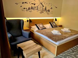 um quarto de hotel com uma cama e uma cadeira em Penzión ** Kolkáreň em Vyhne