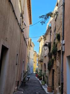 an alley with buildings and plants on the sides of it at Maison In Vino in Nyons