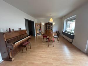 a living room with a piano and a table and chairs at "Spacious Family Apartment & Parking near Strasbourg Center with easy bus Access" in Bischheim