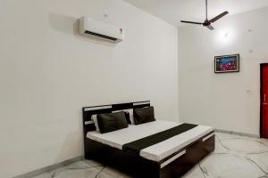 a bedroom with a bed with white walls and a ceiling at OYO Meenaachi Inn in Chennai