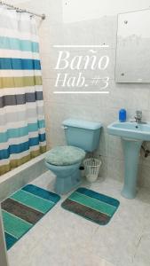 uma casa de banho com um WC azul e um lavatório. em Camu em Camú