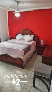 1 dormitorio con 1 cama grande y pared roja en Camu, en Camú
