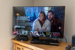 a flat screen tv sitting on top of a table at Dene Croft Cottage in Hexham +9 photos