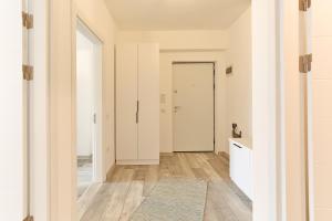 a hallway with white walls and a door with a rug at Ada Homes 07 in Braşov