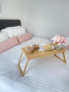 uma mesa de centro com um prato de comida numa cama em Spacious 4 Bedroom, Wi-Fi, 2 Gardens, Sleeps 8 - Amethyst em Cambridge