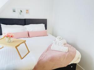 um quarto com uma cama e uma mesa com toalhas em Spacious 4 Bedroom, Wi-Fi, 2 Gardens, Sleeps 8 - Amethyst em Cambridge