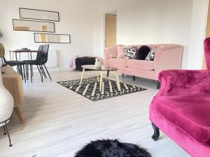 uma sala de estar com um sofá rosa e uma mesa em Spacious 4 Bedroom, Wi-Fi, 2 Gardens, Sleeps 8 - Amethyst em Cambridge
