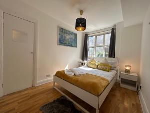 a bedroom with a bed with gold pillows and a window at Marble Arch 3-Bedroom Family Flat in Central London in London