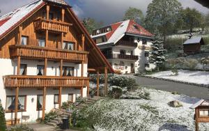 ein Gebäude mit Schnee auf dem Boden davor in der Unterkunft Schwarzwald-Hotel Kraeutle in Feldberg