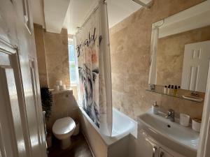 a bathroom with a toilet and a sink and a tub at Marble Arch 3-Bedroom Family Flat in Central London in London