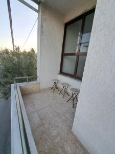 einen Balkon eines Gebäudes mit zwei Tischen und Fenstern in der Unterkunft The house of dreams 2 in Shkodra