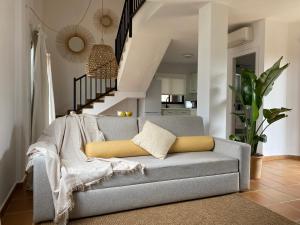 a living room with a couch and a staircase at Nuramar Resort & Villas in Cala en Bosc