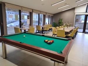 a pool table in a room with tables and chairs at Penzión ** Kolkáreň in Vyhne