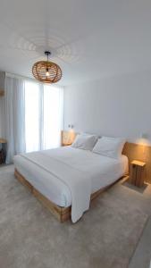 a large white bed in a room with a large window at Square House . Comporta, Portugal in Comporta +25 photos