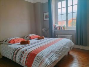 ein Schlafzimmer mit einem Bett mit zwei Kissen und einem Fenster in der Unterkunft Villa 300m de la plage in Le Touquet-Paris-Plage + 4 Fotos