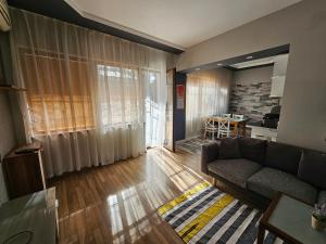 uma sala de estar com um sofá e uma mesa em Grey central apartment em Varna City