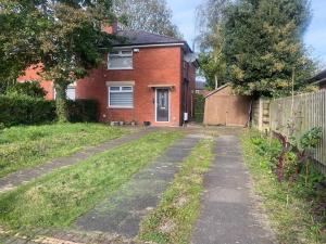 an empty driveway in front of a brick house at A secured 3 bedroom family home in Radcliffe