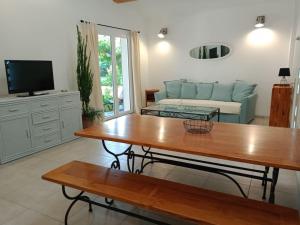 ein Wohnzimmer mit Tisch und Couch in der Unterkunft Villa avec piscine dans un avre de verdure in Caderousse