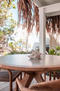 a wooden table on a patio with chairs at Sorobon Luxury Beach Resort in Kralendijk