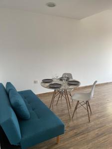 a living room with a blue couch and a table at J V Dubai in Dubai