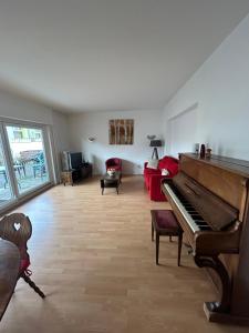 a living room with a piano and a couch at "Spacious Family Apartment & Parking near Strasbourg Center with easy bus Access" in Bischheim +9 photos