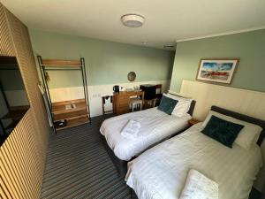a hotel room with two beds and a desk at The Clarendon Hotel in Deal