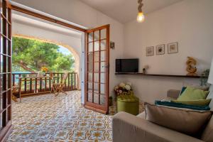 una sala de estar con una puerta que da a un balcón en Villa Elicriso Le Bombarde, Alghero, en Alghero