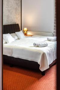 sypialnia z dużym łóżkiem z ręcznikami w obiekcie Browar Gościniec Chojnice w mieście Chojnice