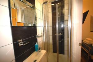 a bathroom with a shower and a toilet and a sink at Corbyn Street Flat 2 in London