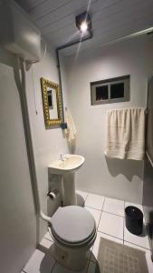 a bathroom with a toilet and a sink at Pousada Sol e Mar in Farol de Santa Marta