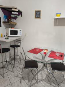 a kitchen with a table and chairs and a microwave at Kitnet Aconchegante in Foz do Iguaçu