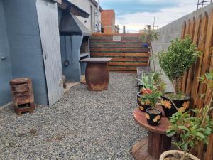 eine Terrasse mit Pflanzen, einer Bank und einem Zaun in der Unterkunft Casa Rural Bella Zaira in El Calafate