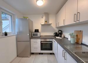 een keuken met witte kasten en een witte koelkast bij ROMA Apartment I Cologne Phantasialand I Köln Messe in Erftstadt