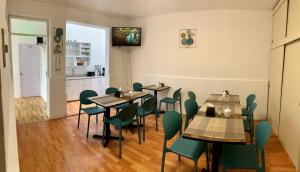 a dining room with tables and green chairs at Península Hostel in Iquique