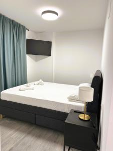 ein Schlafzimmer mit einem Bett und einer Lampe auf einem Tisch in der Unterkunft Esteve Silence in Valencia