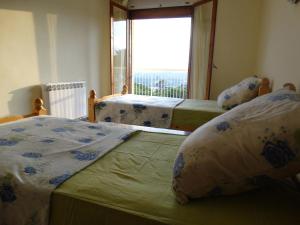 two beds in a room with a large window at House Sabina in Lloret de Mar