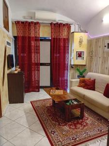 ein Wohnzimmer mit einem Sofa und roten Vorhängen in der Unterkunft il Grottino di Giannas in Pozzuoli
