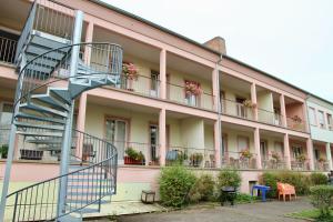 科爾馬的住宿－AUBERGE DE JEUNESSE，粉红色建筑前的螺旋楼梯
