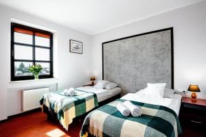 a bedroom with two beds and a window at Browar Gościniec Chojnice in Chojnice