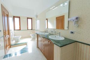 a bathroom with two sinks and a large mirror at Villa Vetrano B&B in Cimitile