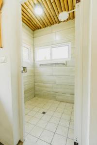 La salle de bains est pourvue d'une douche et de carrelage. dans l'établissement Ocean Paradise, à Barra de Santiago