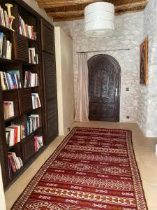 a room with a rug and a book shelf at Dar Volubilis spacieuse villa avec piscine, 5 chambres vue sur forêt in Essaouira
